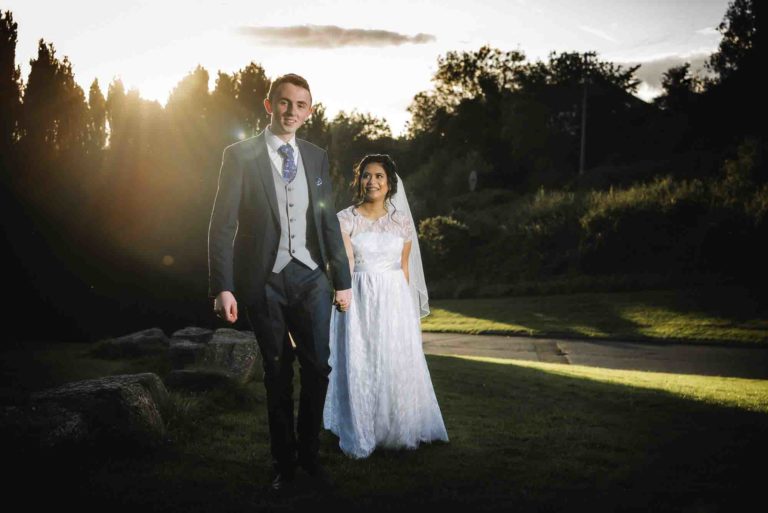 Bride and groom strolling through a garden, surrounded by love in Waterford city