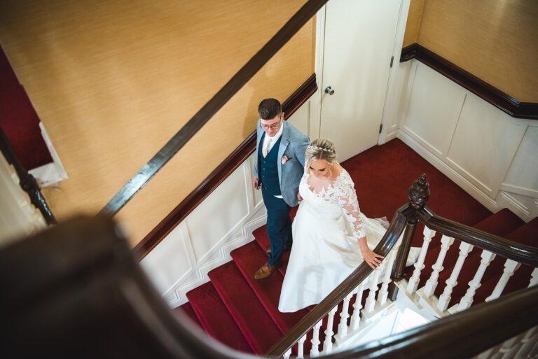 Couple sharing a romantic moment on a vintage staircase at their venue.